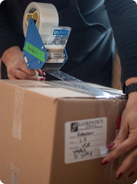 Packing a cardboard box for downsizing moving services - Gordon's Downsizing