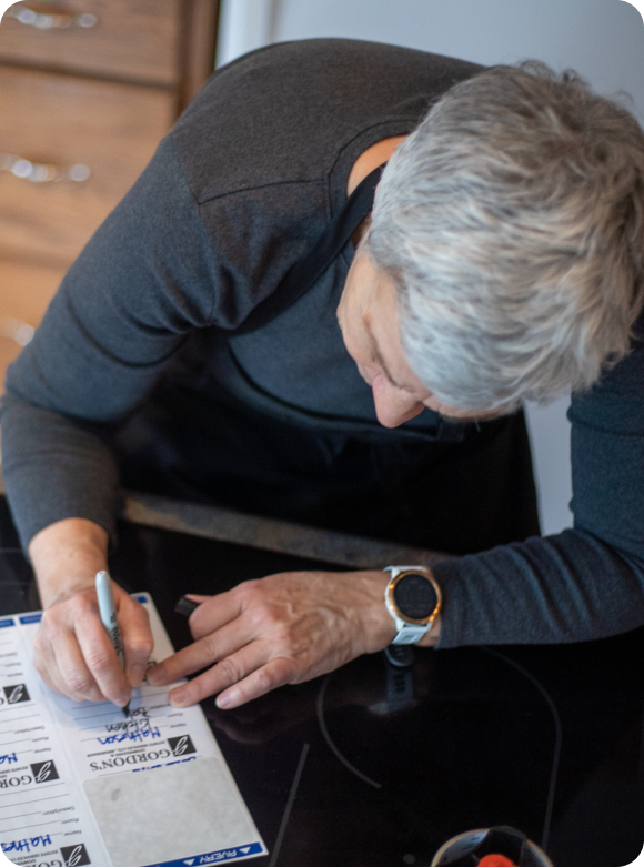 Senior homeowner signing estate settlement service documents - Gordon's Downsizing